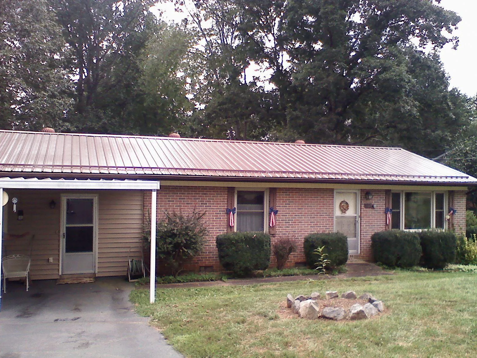 Bronze metal roof and carport on a brick ranch home — Roof Repair work by our crew in Morton